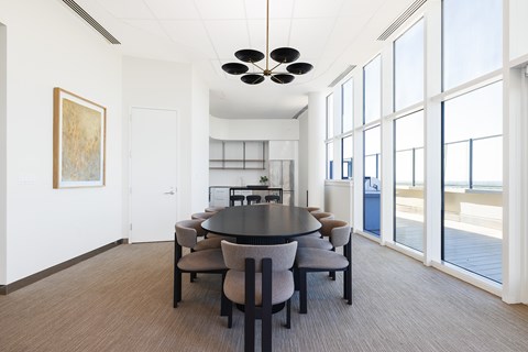 A conference room with a table and chairs and a painting on the wall.