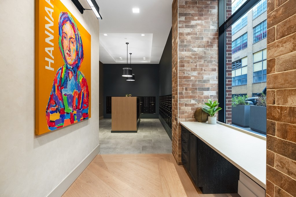 a hallway with exposed brick walls and a painting on the wall