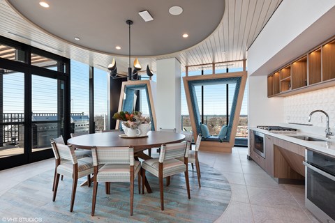 A modern dining room with a round table and chairs.