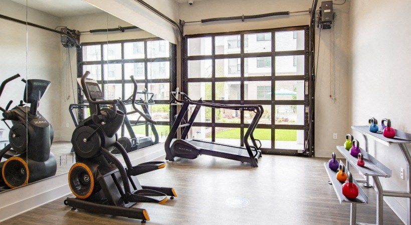 a workout room with weights in front of a window