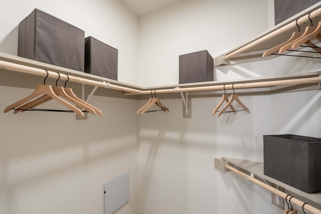 a laundry room with shelves and hangers on the wall