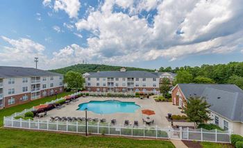 A large apartment complex with a pool and a fenced in area.