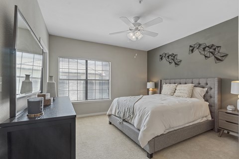 A bedroom with a large bed and a ceiling fan.