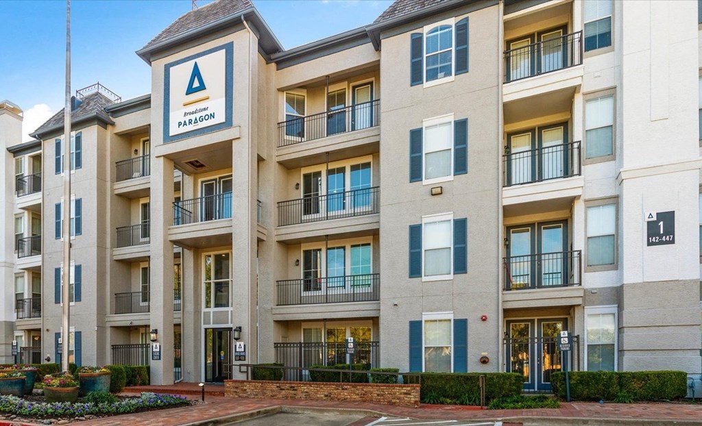a building with multiple balconies and a sign on the side of it