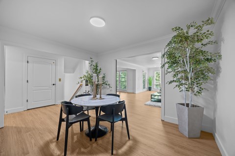 A dining room with a table and chairs.