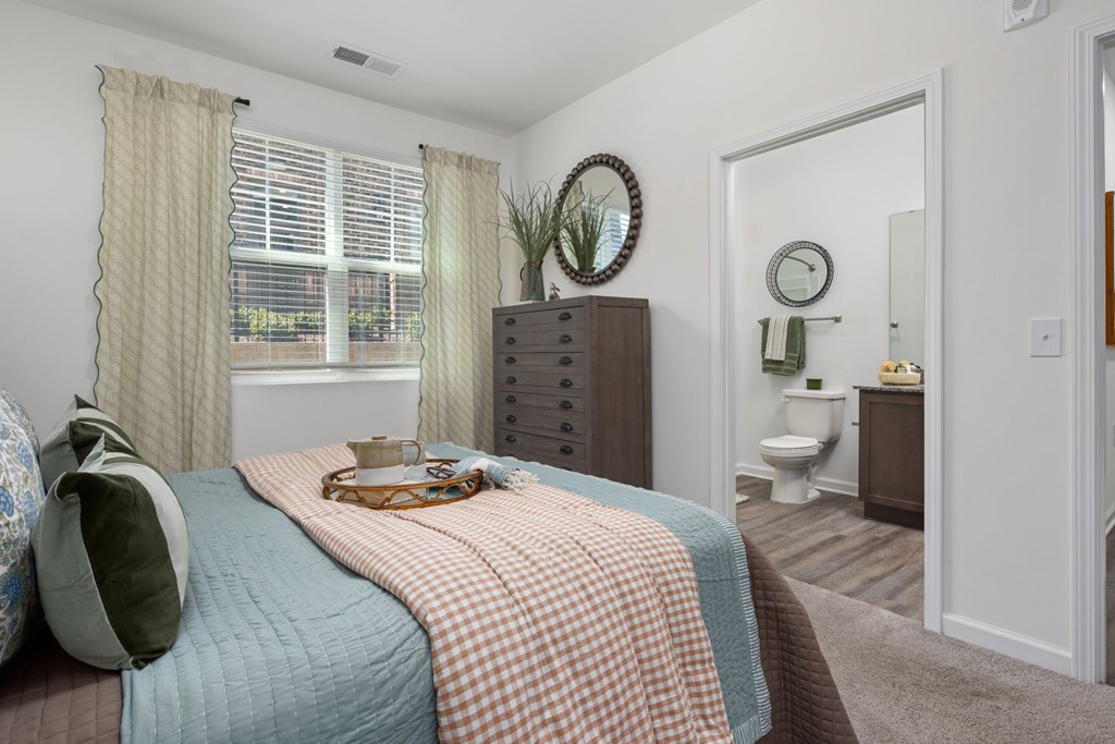 A bedroom with a bed, dresser, and mirror.