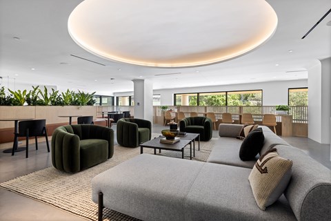 A modern living room with a grey sofa and green armchairs.