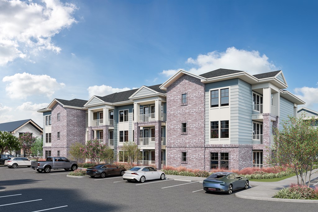 A modern apartment building with a parking lot in front.