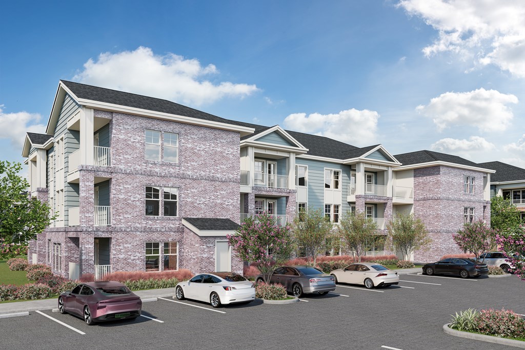 A row of houses with cars parked in front.