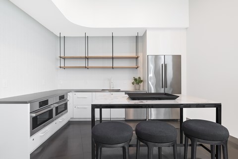 A modern kitchen with white cabinets and a black countertop.