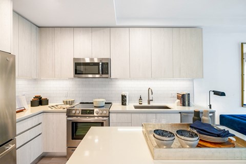 a modern kitchen with white cabinets and stainless steel appliances