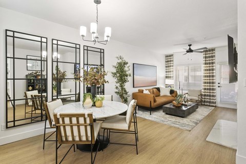 A modern living room with a dining table and chairs.