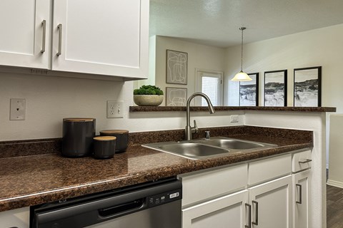 a kitchen with white cabinets and a sink and a counter top