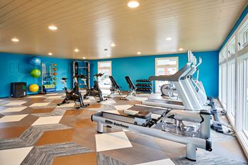 A gym with a variety of equipment including a rowing machine.