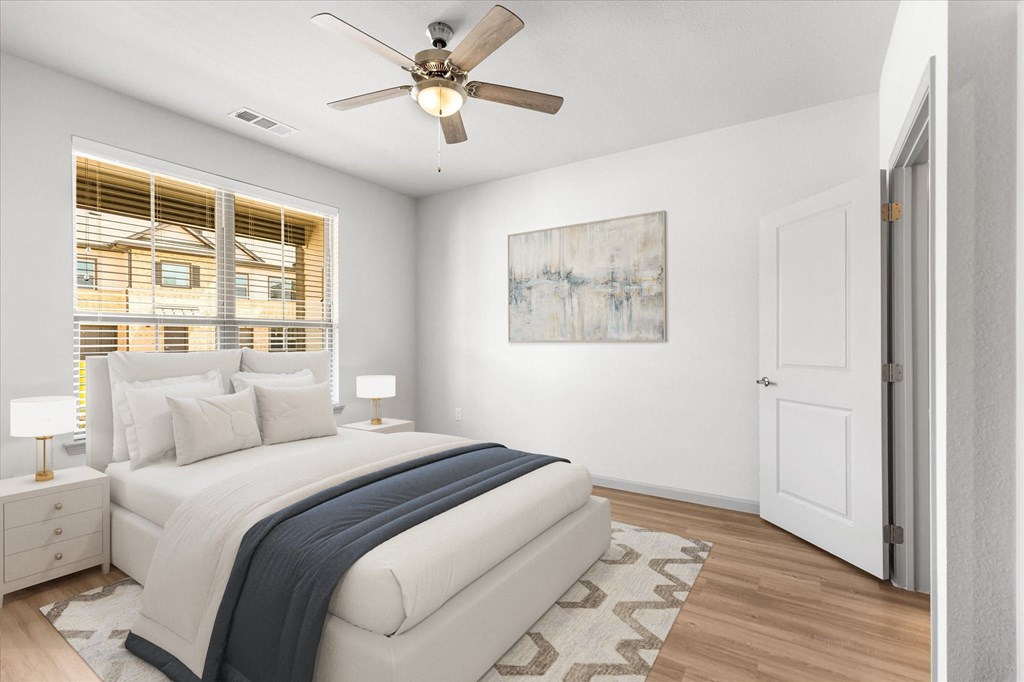 a bedroom with a large bed and a ceiling fan