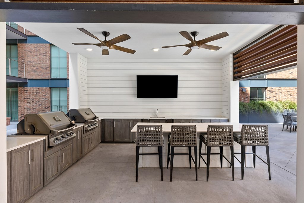 A patio with a table and chairs and a television on the wall.