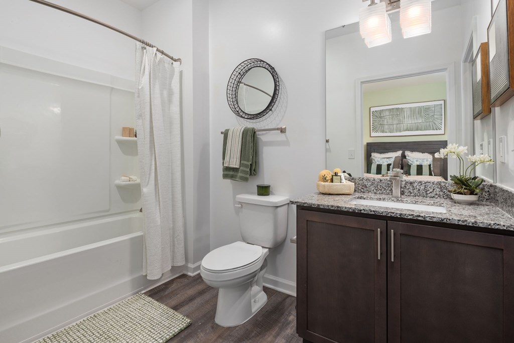 A bathroom with a toilet, sink, and shower.