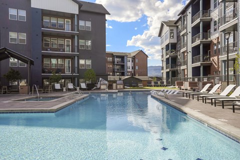 A large swimming pool in front of apartment buildings.