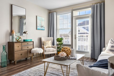 A living room with a white sofa, a wooden dresser, a mirror, and a painting on the wall.