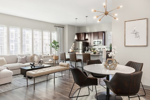 A modern living room with a dining table and chairs.