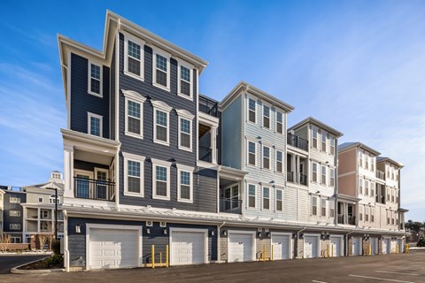A row of modern townhouses with garages in front.