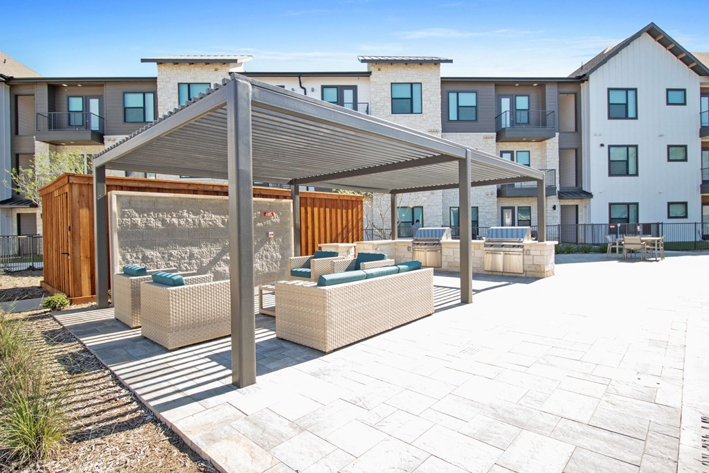 a patio with awnings and benches in front of some apartments