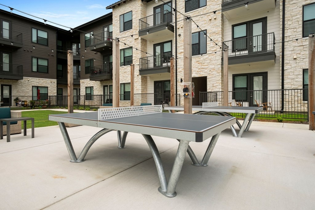 two ping pong tables in front of an apartment building