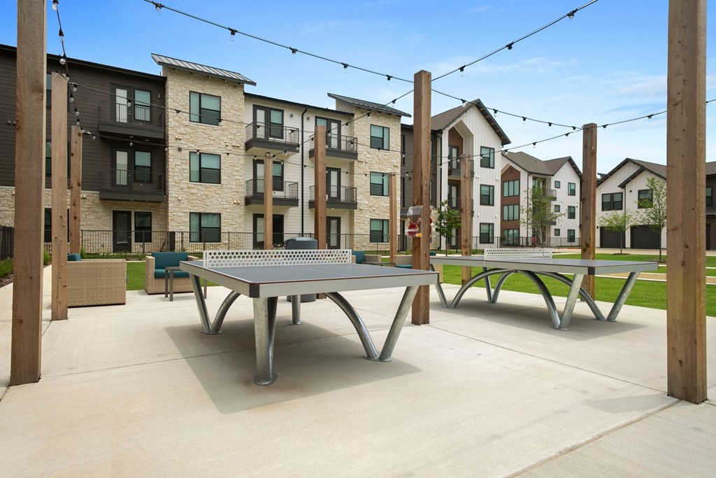 a ping pong table on a patio with apartments in the background
