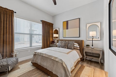 A bedroom with a large bed and a ceiling fan.