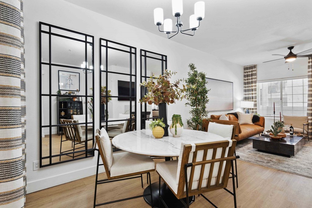 A dining room with a white table and chairs.