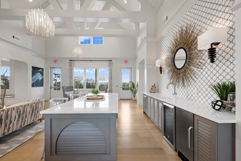 A modern kitchen with a white island and a large window.