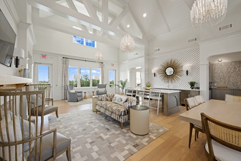 A spacious living room with a dining area and a kitchen in the background.