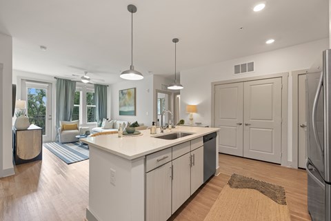A modern kitchen with a large island and wooden floors.