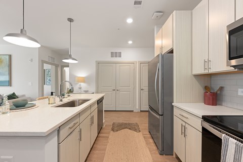 A kitchen with white cabinets and a refrigerator.