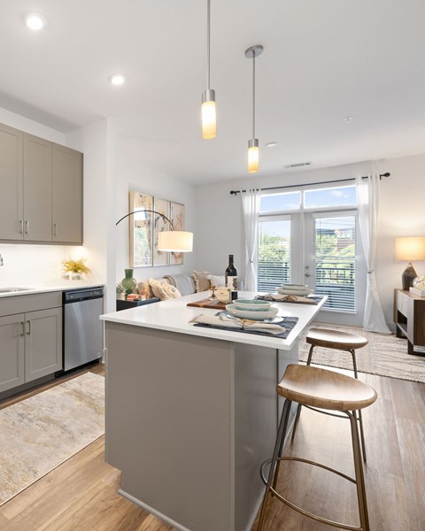 A modern kitchen with a bar stool in front of the island.