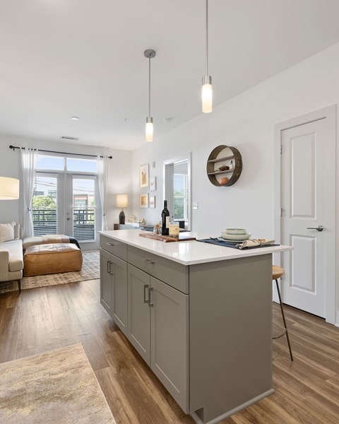 A kitchen with a white island and wooden floors.