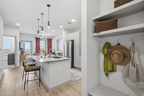A kitchen with a white counter and a stool.