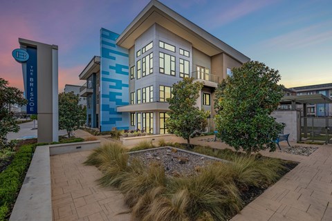 A modern building with a blue and white facade is labeled "The Brisco".