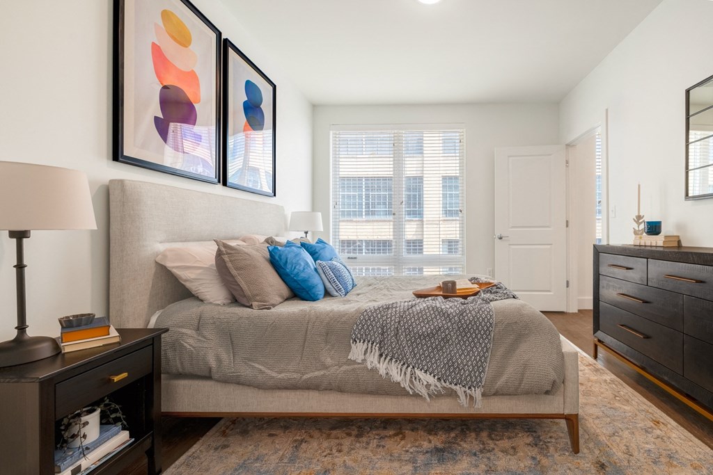 a bedroom with a bed and a dresser and a window