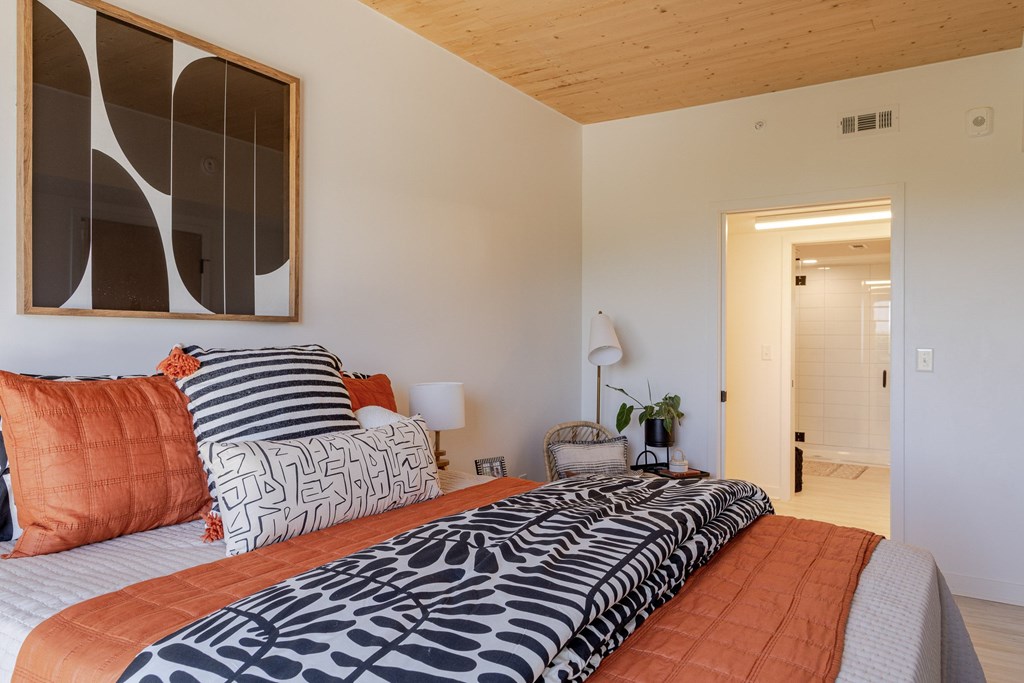 A bedroom with a bed and a lamp.