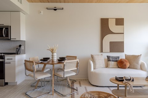 A modern living room with a dining table and chairs.
