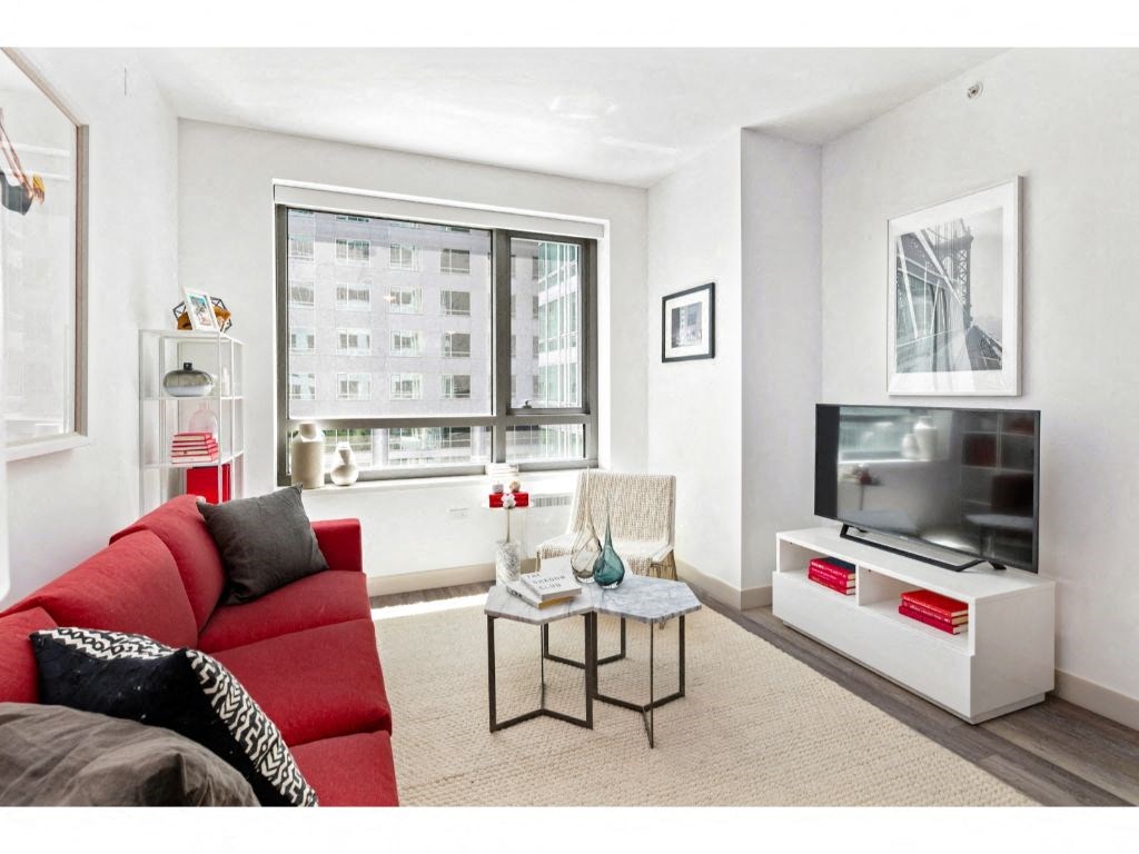 a living room with a red couch and a large window