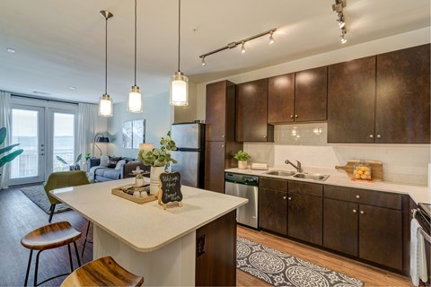 A kitchen with a white island and brown cabinets.