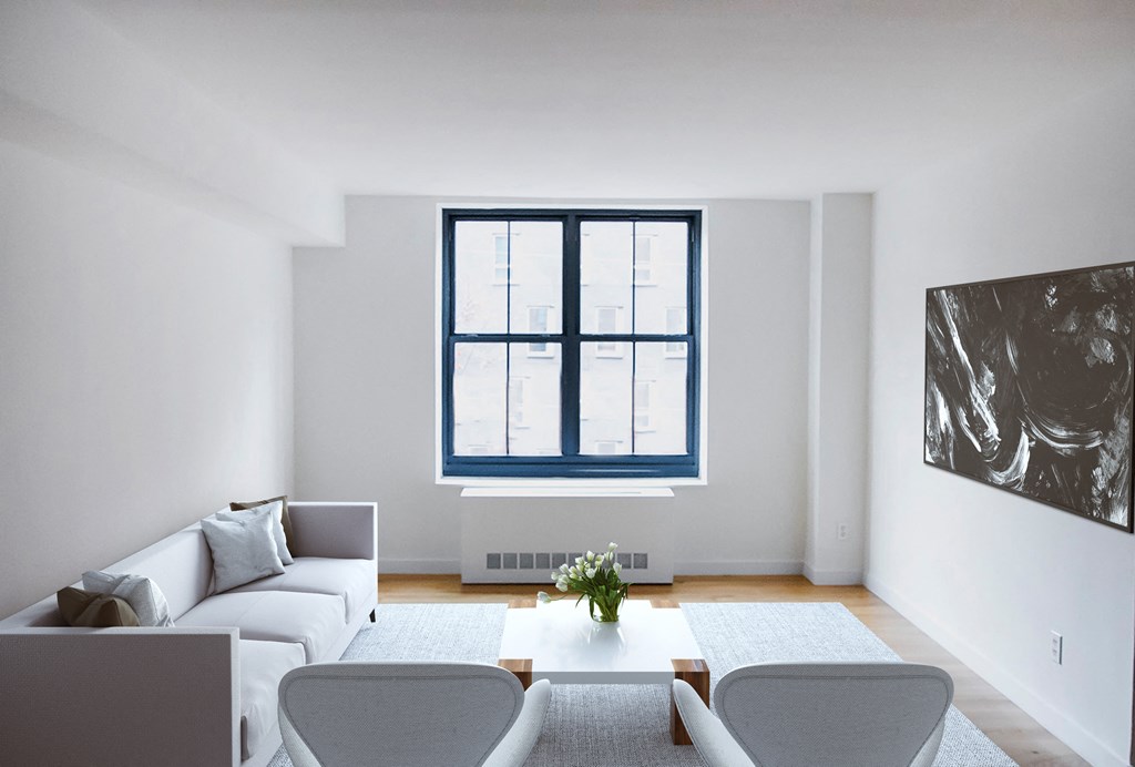 a living room with white furniture and a window