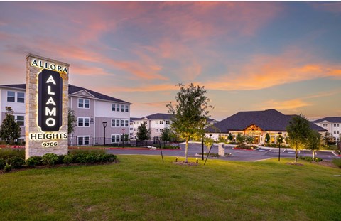 a city with a sign for alamo heights at sunset