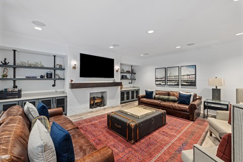 A living room with a fireplace, a couch, and a rug.