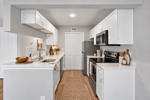 A kitchen with white cabinets and appliances.