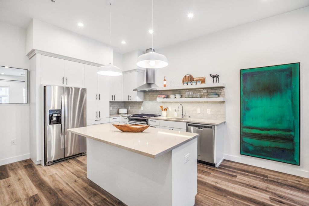 a kitchen with a large center island next to a stove top oven