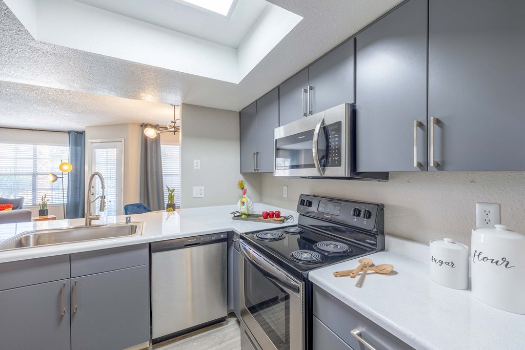 a kitchen with gray cabinets and white countertops