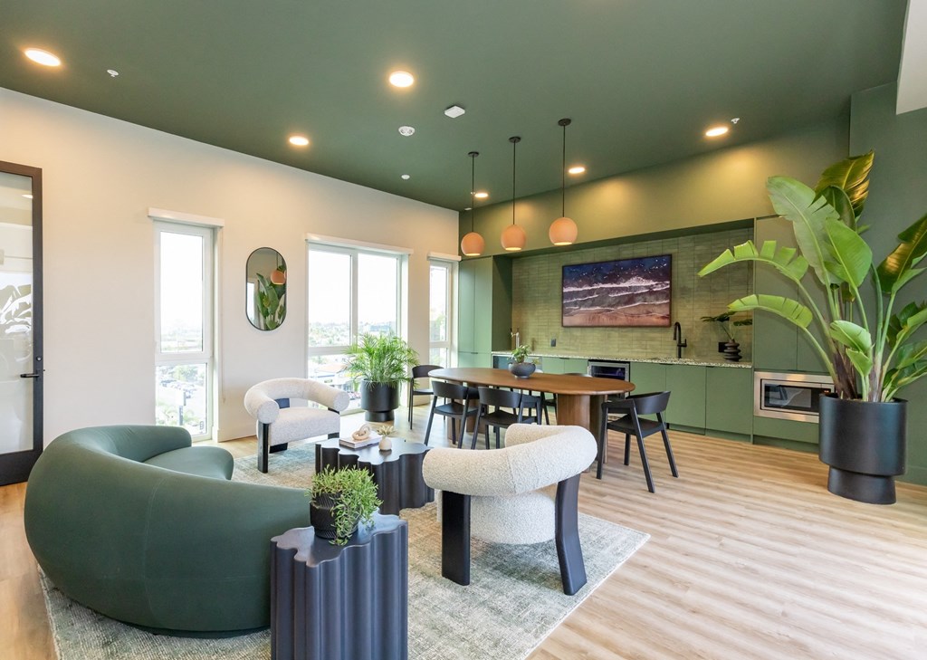 a living room and dining room with green walls and wood floors